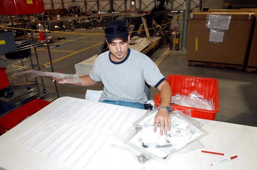 KENNEDY SPACE CENTER, FLA.  -  A worker in the Columbia Debris Hangar sorts bagged items of Columbia debris that will be transferred to storage in the Vehicle Assembly Building.  About 83,000 pieces were shipped to KSC during search and recovery efforts in East Texas.