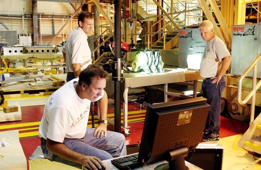 KENNEDY SPACE CENTER, FLA. -  John Macke (standing, left), with Boeing St. Louis, Alden Pitard (seated, left) and Dan Clark (right), with KSC Boeing, look at a monitor after 3D digital scanning of actuators in the Orbiter Processing Facility.  There are two actuators per engine on the Shuttle, one f