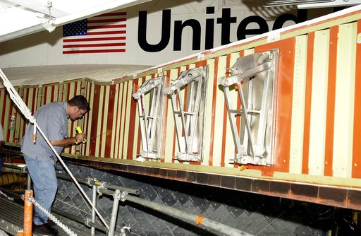 KENNEDY SPACE CENTER, FLA. - In the Orbiter Processing Facility, John Newport, with United Space Alliance, inspects the wing of the orbiter Atlantis before installing a spar. Reinforced Carbon Carbon (RCC) panels are mechanically attached to the wing with a series of floating joints - spars - to red