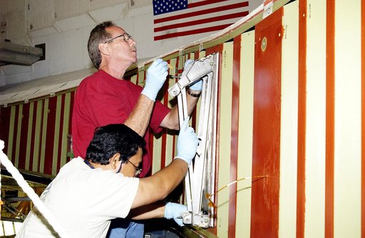 KENNEDY SPACE CENTER, FLA. - In the Orbiter Processing Facility, Mike Hyatt (above) and Saul Ngy (below), with United Space Alliance, install a spar on the wing of the orbiter Atlantis.  Reinforced Carbon Carbon (RCC) panels are mechanically attached to the wing with a series of floating joints - sp