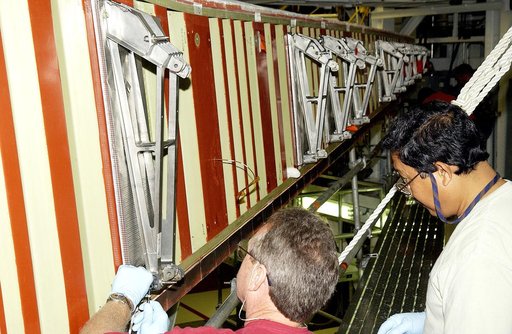 KENNEDY SPACE CENTER, FLA. - In the Orbiter Processing Facility, Mike Hyatt (left) and Saul Ngy (right), with United Space Alliance, finish installing a spar on the wing of the orbiter Atlantis.  Reinforced Carbon Carbon (RCC) panels are mechanically attached to the wing with a series of floating jo