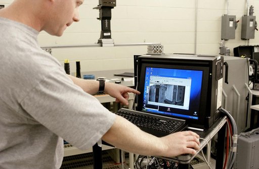 KENNEDY SPACE CENTER, FLA. - In the Vehicle Assembly Building, Jim Landy, NDE specialist, examines flight crew lockers using flash thermography.  He is screening the lockers for hidden damage underneath dings and dents that might occur during handling.