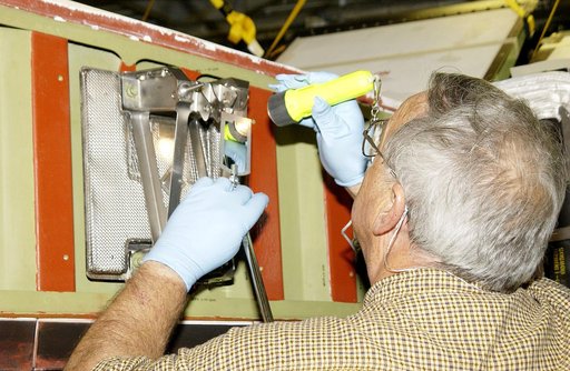 KENNEDY SPACE CENTER, FLA. - In the Orbiter Processing Facility, Jerry Belt, with United Space Alliance, checks a spar attachment on the wing of the orbiter Atlantis before installing Reinforced Carbon Carbon (RCC) panels on the wing.  The spars - floating joints - reduce loading on the panels cause