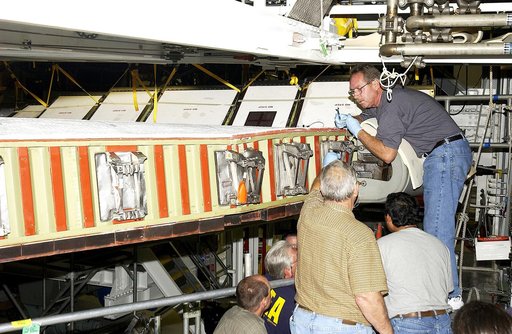 KENNEDY SPACE CENTER, FLA. -  In the Orbiter Processing Facility, United Space Alliance worker Mike Hyatt (above) attaches a Reinforced Carbon Carbon (RCC) panel onto the leading edge of the wing of the orbiter Atlantis.  The gray carbon composite RCC panels have sufficient strength to withstand the
