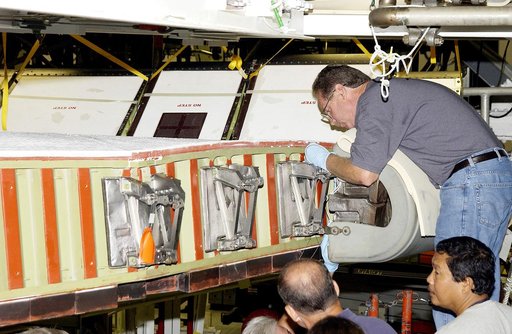 KENNEDY SPACE CENTER, FLA. - In the Orbiter Processing Facility, United Space Alliance worker Mike Hyatt (above) completes installation of a Reinforced Carbon Carbon (RCC) panel onto the leading edge of the wing of the orbiter Atlantis.  The gray carbon composite RCC panels have sufficient strength 
