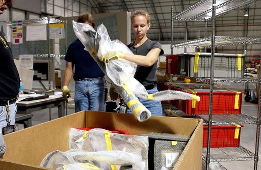 KENNEDY SPACE CENTER, FLA. - James Harrison (left), Jack Nowling (center) and Amy Norris (right) pack up some of the debris stored in the Columbia Debris Hangar.  About 83,000 pieces were shipped to KSC during search and recovery efforts in East Texas. An area of the Vehicle Assembly Building is bei