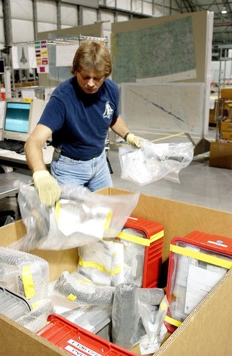 KENNEDY SPACE CENTER, FLA. - In the Columbia Debris Hangar, Jack Nowling transfers bags with debris pieces into a storage box.  About 83,000 pieces of debris were shipped to KSC during search and recovery efforts in East Texas. That represents about 38 percent of the dry weight of Columbia, equaling