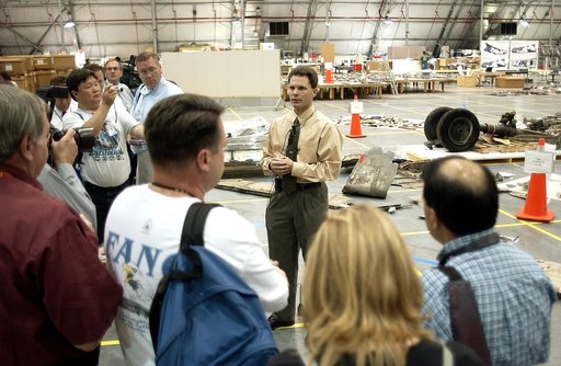 KENNEDY SPACE CENTER, FLA. - In the Columbia Debris Hangar, Scott Thurston, NASA vehicle flow manager, addresses the media about efforts to pack the debris stored in the Columbia Debris Hangar.  More than 83,000  pieces of debris were shipped to KSC during search and recovery efforts in East Texas. 
