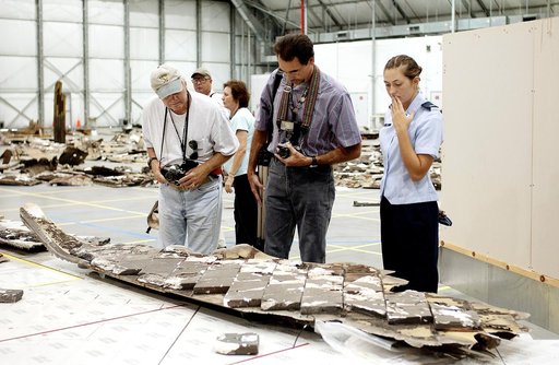 KENNEDY SPACE CENTER, FLA. - During a media tour of the Columbia Debris Hangar, photographers look at pieces of tile collected during search and recovery efforts in East Texas.  About 83,000 pieces of debris from Columbia were shipped to KSC, which represents about 38 percent of the dry weight of Co