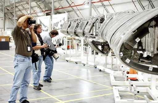 KENNEDY SPACE CENTER, FLA. - During a media tour of the Columbia Debris Hangar, photographers pause at the mockup of the leading edge of Columbia’s left wing.  About 83,000 pieces of debris from Columbia were shipped to KSC from search and recovery efforts in East Texas.  About 83,000 pieces of debr