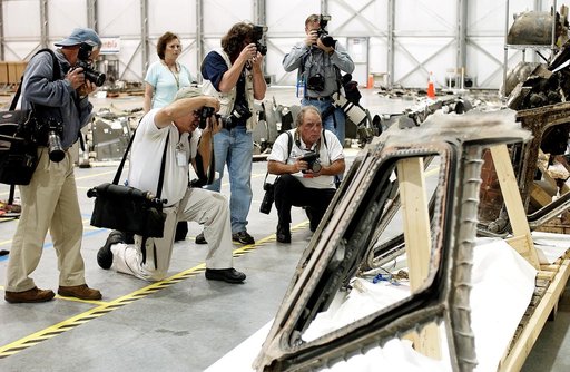 KENNEDY SPACE CENTER, FLA. - During a media tour of the Columbia Debris Hangar, photographers focus on part of the cockpit collected from search and recovery efforts in East Texas. About 83,000 pieces of debris from Columbia were shipped to KSC, which represents about 38 percent of the dry weight of