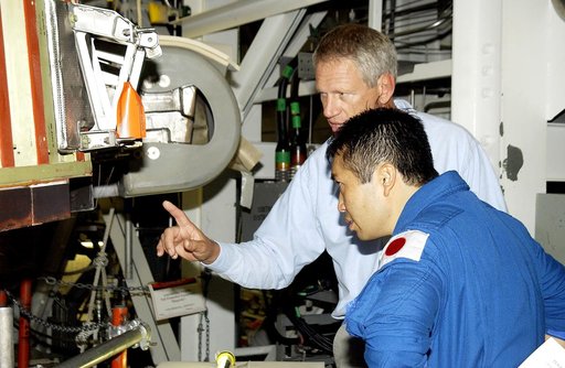 KENNEDY SPACE CENTER, FLA. - Japanese astronaut Koichi Wakata (front) listens to William Gaetjens, with the Vehicle Integration Test Team (VITT), who is providing details about the spar installation (left) on the wing of the orbiter Atlantis.  Reinforced Carbon Carbon (RCC) panels are mechanically a