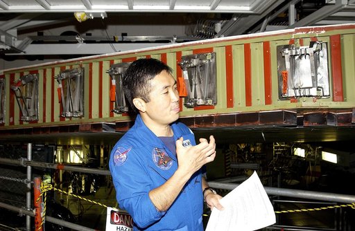 KENNEDY SPACE CENTER, FLA. - Japanese astronaut Koichi Wakata gestures as he examines the spar installation (behind him) on the wing of the orbiter Atlantis.  Reinforced Carbon Carbon (RCC) panels are mechanically attached to the wing via the spars - a series of floating joints - to reduce loading o