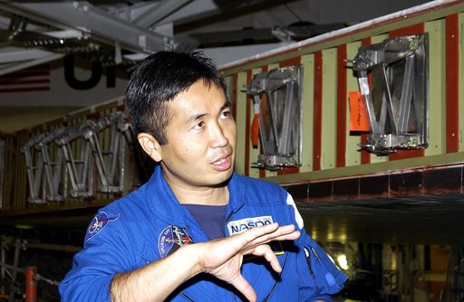 KENNEDY SPACE CENTER, FLA. - Japanese astronaut Koichi Wakata gestures as he examines the spar installation (behind him) on the wing of the orbiter Atlantis.  Reinforced Carbon Carbon (RCC) panels are mechanically attached to the wing via the spars - a series of floating joints - to reduce loading o