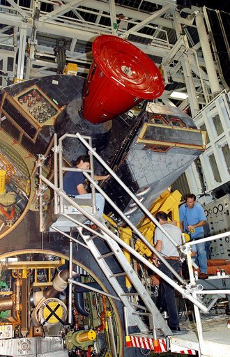 KENNEDY SPACE CENTER, FLA. -  Workers in the Orbiter Processing Facility prepare to  remove one of two orbital maneuvering system (OMS) pods from Endeavour.  The OMS pods are attached to the upper aft fuselage left and right sides.  Fabricated primarily of graphite epoxy composite and aluminum, each