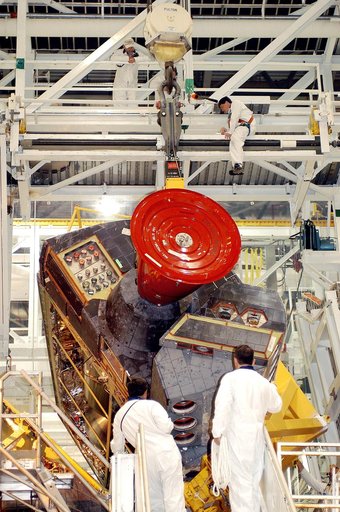 KENNEDY SPACE CENTER, FLA. -   Technicians in the Orbiter Processing Facility oversee removal of one of two orbital maneuvering system (OMS) pods from Endeavour.  The OMS pods are attached to the upper aft fuselage left and right sides.  Fabricated primarily of graphite epoxy composite and aluminum,