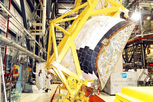 KENNEDY SPACE CENTER, FLA. -  In the Orbiter Processing Facility, one of two orbital maneuvering system (OMS) pods removed from Endeavour is lowered onto a transporter.  The OMS pods are attached to the upper aft fuselage left and right sides.  Fabricated primarily of graphite epoxy composite and al