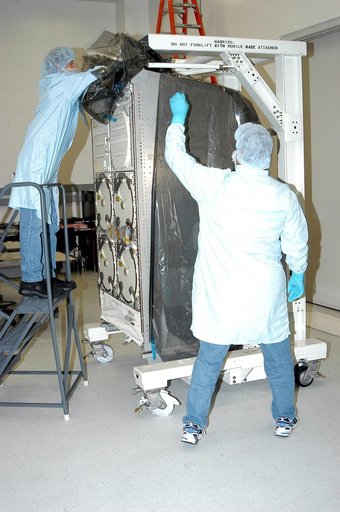 KENNEDY SPACE CENTER, FLA. -  In the Space Station Processing Facility, technicians remove the cover from the Minus Eighty Lab Freezer for ISS(MELFI) provided as Laboratory Support Equipment by the European Space Agency for the International Space Station.  The lab will provide cooling and storage f