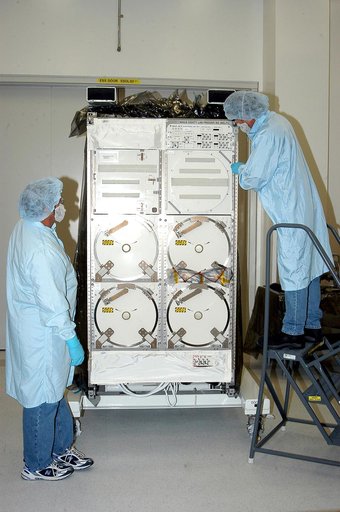 KENNEDY SPACE CENTER, FLA. -  After removing its cover, technicians look over the Minus Eighty Lab Freezer for ISS (MELFI),  provided as Laboratory Support Equipment by the European Space Agency for the International Space Station.  The lab will provide cooling and storage for reagents, samples and 