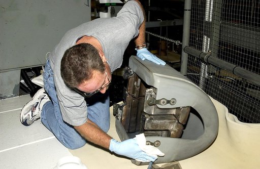 KENNEDY SPACE CENTER, FLA. -  In the Orbiter Processing Facility, United Space Alliance worker Mike Hyatt looks over a Reinforced Carbon Carbon (RCC) panel that will be attached to the leading edge of the wing of the orbiter Atlantis.  The gray carbon composite RCC panels have sufficient strength to