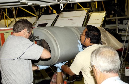 KENNEDY SPACE CENTER, FLA. -  In the Orbiter Processing Facility, United Space Alliance workers Mike Hyatt (left), Saul Ngy (center) and Jerry Belt (right) prepare to install a Reinforced Carbon Carbon (RCC) panel to the leading edge of the wing of the orbiter Atlantis.  The gray carbon composite RC