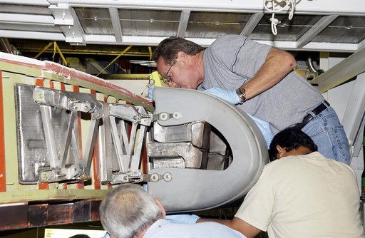 KENNEDY SPACE CENTER, FLA. -  In the Orbiter Processing Facility, United Space Alliance workers  Mike Hyatt (above),  Saul Ngy (right) and Jerry Belt (below) install a Reinforced Carbon Carbon (RCC) panel to the leading edge of the wing of the orbiter Atlantis.  The gray carbon composite RCC panels 