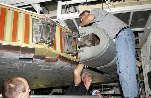 KENNEDY SPACE CENTER, FLA. - In the Orbiter Processing Facility, United Space Alliance worker Mike Hyatt (above) finishes installing a Reinforced Carbon Carbon (RCC) panel to the leading edge of the wing of the orbiter Atlantis.  The gray carbon composite RCC panels have sufficient strength to withs