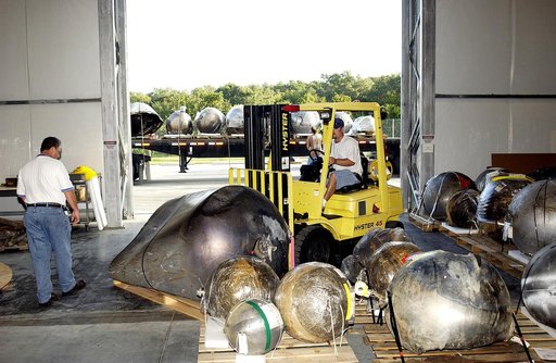 KENNEDY SPACE CENTER, FLA. -    Some of the Columbia debris inside the Columbia Debris Hangar is being moved out and placed on a flatbed truck (seen in the background) for transfer to the Vehicle Assembly Building for permanent storage.  More than 83,000  pieces of debris were shipped to KSC during 