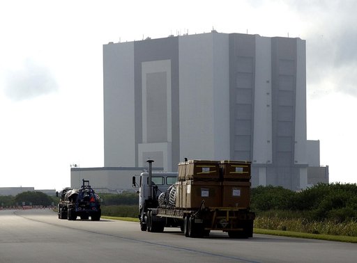 KENNEDY SPACE CENTER, FLA. -  Flatbed trucks carrying some of the debris of Space Shuttle Columbia approach the Vehicle Assembly Building (VAB).  The debris is being transferred from the Columbia Debris Hangar to the VAB for permanent storage.  More than 83,000 pieces of debris were shipped to KSC d