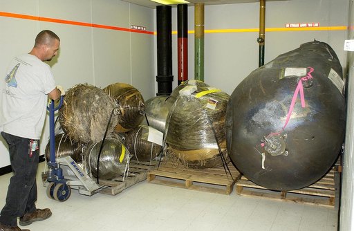 KENNEDY SPACE CENTER, FLA. -  A worker moves some of the Columbia debris to its storage site in the Vehicle Assembly Building (VAB). The debris is being transferred from the Columbia Debris Hangar to the VAB for permanent storage.  More than 83,000 pieces of debris were shipped to KSC during search 