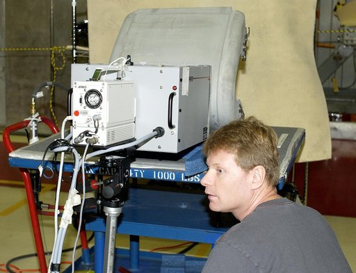 KENNEDY SPACE CENTER, FLA. - In the Orbiter Processing Facility,  Jim Landy, NDE specialist with United Space Alliance (USA), watches a monitor off-screen to examine a Reinforced Carbon Carbon panel using flash thermography.  Attached to the leading edge of the wing of the orbiters,  the gray carbon