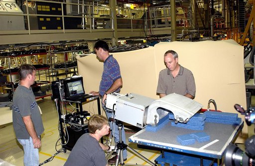 KENNEDY SPACE CENTER, FLA. - In the Orbiter Processing Facility, United Space Alliance workers share the task of examining  a Reinforced Carbon Carbon panel using flash thermography.  From left are Paul Ogletree, Jim Landy (kneeling), Dan Phillips and Dan Kenna.  Attached to the leading edge of the 