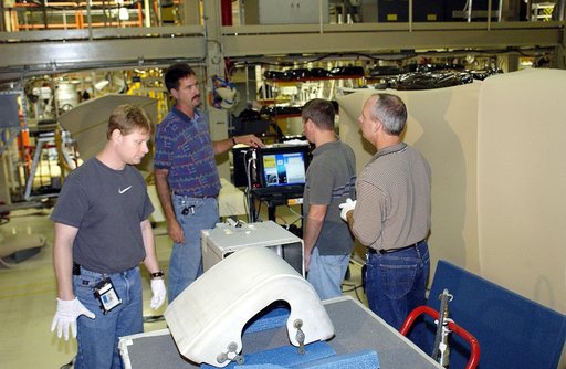 KENNEDY SPACE CENTER, FLA. - In the Orbiter Processing Facility, United Space Alliance workers (left to right) Jim Landy, Dan Phillips, Paul Ogletree and Dan Kenna check results of flash thermography on the Reinforced Carbon Carbon panel on the table (foreground).  Attached to the leading edge of th