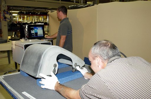 KENNEDY SPACE CENTER, FLA. -  In the Orbiter Processing Facility, United Space Alliance worker Dan Kenna (right) positions a Reinforced Carbon Carbon panel on the table to perform flash thermography.  In the background, Paul Ogletree observes the monitor.  Attached to the leading edge of the wing of