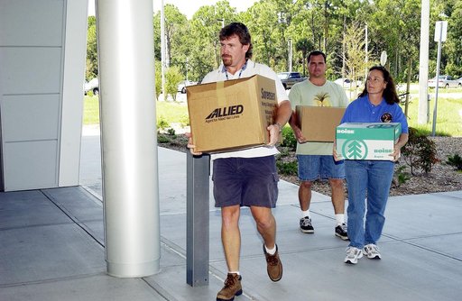 KENNEDY SPACE CENTER, FLA. -  Dynamac employees (from left) Larry Burns, Debbie Wells and Neil  Yorio carry boxes of hardware into the Space Life Sciences Lab (SLSL), formerly known as the Space Experiment Research and Processing Laboratory (SERPL).  They are transferring equipment from Hangar L. Th
