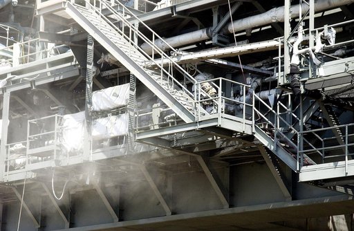 KENNEDY SPACE CENTER, FLA. - Workers, covered in protective clothing and breathing apparatus, continue sandblasting on the Mobile Launcher Platform on Launch Pad 39A to remove corrosion before repainting.  Routine maintenance includes sandblasting and repainting as preventive means to minimize corro