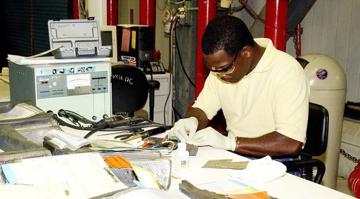 KENNEDY SPACE CENTER, FLA. -   United Space Alliance employee Anthony Simmons prepares to electroweld a crack found on an insulator inside a Reinforced Carbon Carbon panel.   The gray carbon composite RCC panels are attached to the leading edge of the wing of the orbiters to withstand the aerodynami