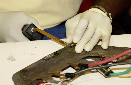 KENNEDY SPACE CENTER, FLA. -   United Space Alliance employee Anthony Simmons continues electrowelding on an insulator inside a Reinforced Carbon Carbon panel.   The gray carbon composite RCC panels are attached to the leading edge of the wing of the orbiters to withstand the aerodynamic forces expe