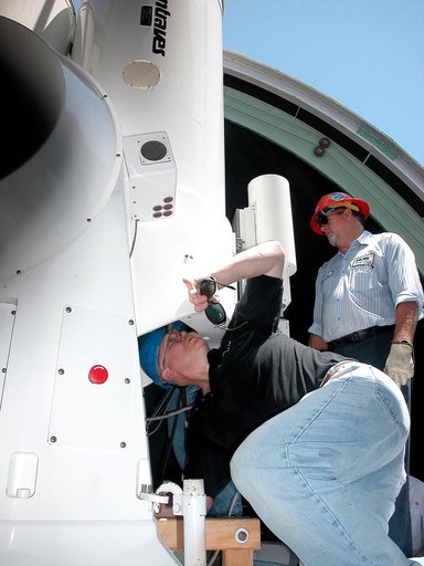 KENNEDY SPACE CENTER, FLA. -  A worker looks at a five-meter (focal length) telescope being removed for repair.  Part of the Distant Object Attitude Measurement System (DOAMS) in Cocoa Beach, Fla., the tracking telescope provides optical support for launches from KSC and Cape Canaveral. .