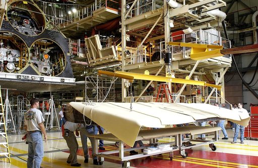 KENNEDY SPACE CENTER, FLA. -   Workers in the Orbiter Processing Facility get ready to lift and install the rear body flap on orbiter Discovery.  The body flap, which is temporarily under protective covering, attaches below the main engines.