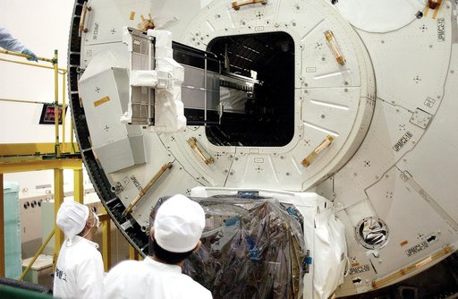 KENNEDY SPACE CENTER, FLA. - In the Space Station Processing Facility, technicians on the floor watch as a tray is extended from inside the Pressurized Module, or PM, part of the Japanese Experiment Module (JEM).   The PM provides a shirt-sleeve environment in which astronauts on the International S