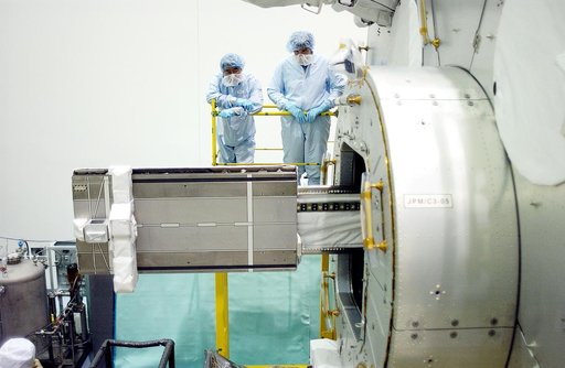 KENNEDY SPACE CENTER, FLA. -  In the Space Station Processing Facility, Japanese astronaut Koichi Wakata (top left) and technicians watch as a tray is extended from inside the Pressurized Module, or PM, part of the Japanese Experiment Module (JEM).   The PM provides a shirt-sleeve environment in whi