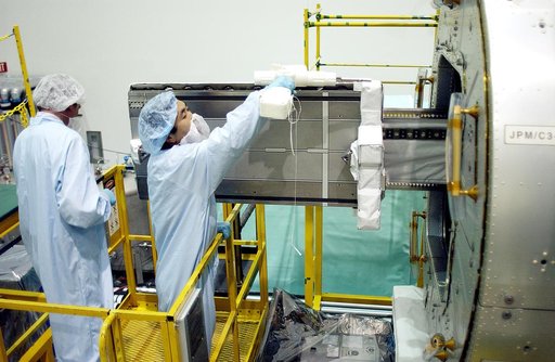 KENNEDY SPACE CENTER, FLA. -   Japanese astronaut Koichi Wakata (right) works with a tray extended  from inside the Pressurized Module, or PM, part of the Japanese Experiment Module (JEM).   The PM provides a shirt-sleeve environment in which astronauts on the International Space Station can conduct