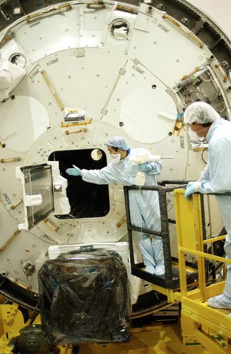 KENNEDY SPACE CENTER, FLA. -   Japanese astronaut Koichi Wakata (left) releases a tray  extended from inside the Pressurized Module, or PM, that he was working with.  Part of the Japanese Experiment Module (JEM), the PM provides a shirt-sleeve environment in which astronauts on the International Spa