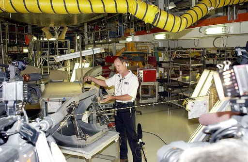 KENNEDY SPACE CENTER, FLA. -  In the Orbiter Processing Facility (OPF), Rick Beckwith, an orbiter engineer with United Space Alliance, explains to the media the reinstallation of the Reinforced Carbon-Carbon panels on Atlantis’ wing leading edge.  The media was invited to tour the OPF at KSC and to 