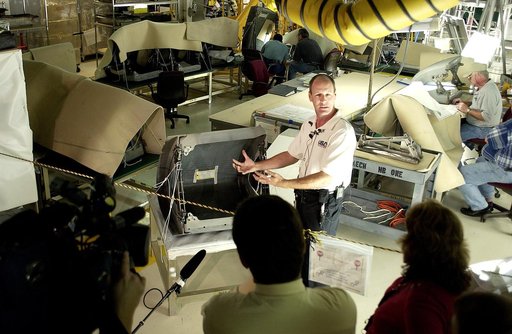 KENNEDY SPACE CENTER, FLA. -  In the Orbiter Processing Facility (OPF), Rick Beckwith, an orbiter engineer with United Space Alliance, explains to the media the reinstallation of the Reinforced Carbon-Carbon panels on the orbiter Atlantis’ wing leading edge.  The media was invited to tour the OPF at