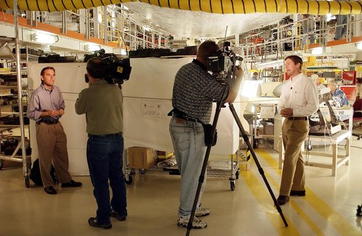 KENNEDY SPACE CENTER, FLA. - Local Central Florida television reporters Phil Robertson (left), with WFTV, and Dan Billow (right), with WESH, tape commentaries after a media tour of the Orbiter Processing Facility.  The media was invited to see the orbiter Atlantis as it is being prepared for Return 