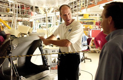 KENNEDY SPACE CENTER, FLA. -  In the Orbiter Processing Facility, Rick Beckwith (center), an orbiter engineer with United Space Alliance, explains to the media the reinstallation of the Reinforced Carbon-Carbon panels on the orbiter Atlantis’ wing leading edge.  The media was invited to tour the OPF