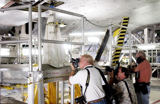 KENNEDY SPACE CENTER, FLA. -  In the Orbiter Processing Facility,  the media photograph work being done on the tiles on the orbiter Atlantis as it is being prepared for Return to Flight in the Orbiter Processing Facility.   Both local and national reporters representing print and TV networks were ab