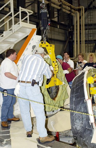 KENNEDY SPACE CENTER, FLA. - In the Orbiter Processing Facility, workers secure the nose cap of the orbiter Atlantis for its transfer to a stand.  The cap was removed for routine inspection. The nose cap is made of reinforced carbon-carbon (RCC), which has an operating range of minus 250° F to about